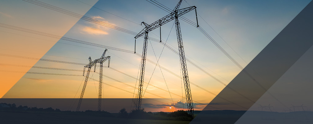 Linie energetyczne na tle zachodzącego słońca, będące symbolem cen energii